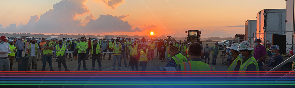 Worksite safety meeting at sunrise