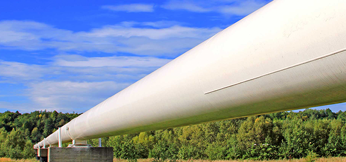 white pipeline with blue sky and trees